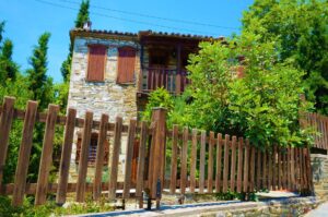 Stonehouse with green yard in Old Town of Nikiti